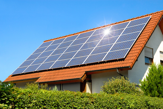 Solar panel on a red roof Solar panel on a red roof reflecting the sun and the cloudless blue sky